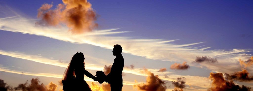 A couple marrying in front of a beautiful sky